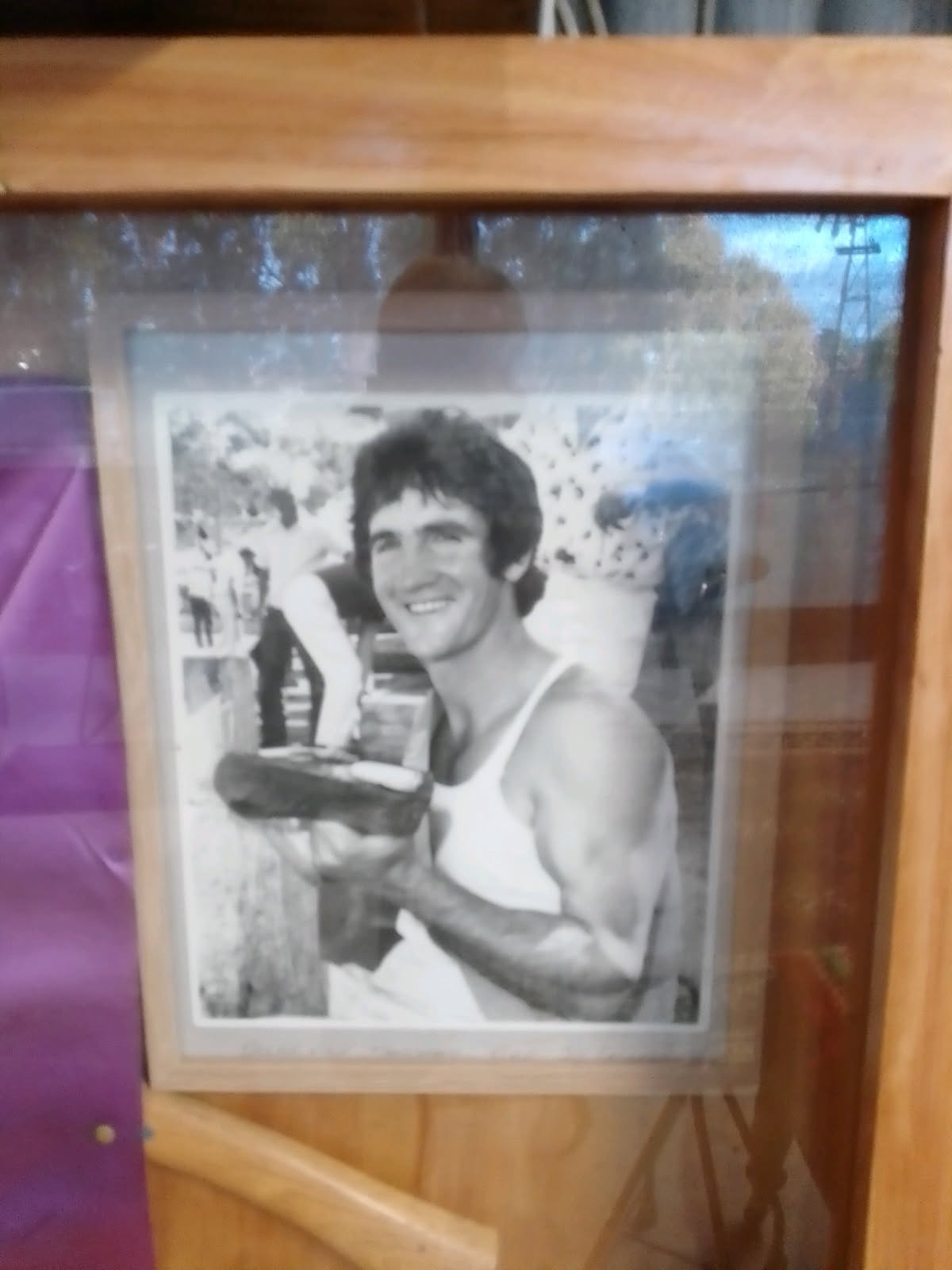 Black and white image of a young pat holding a trophy
